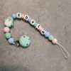 Kreativ smokkelenke i fargene mintgrønn, babyblå og babyrosa. Prydet med mintgrønn pingvin og rund klips i silikon.