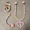 Personlig gavesett til baby med vognlenke, bitering og smokkelenke i babyrosa, beige og duse farger.