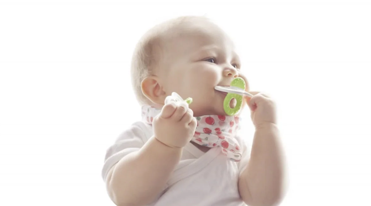 Myk baby med smokk og tåteflaske, fokus på babypleie og amming, i lyst rom. Babysjarm.no tilbyr produkter for komfort og omsorg til spedbarn. Utstyr som gjør barneoppdragelse enklere og mer komfortabelt.